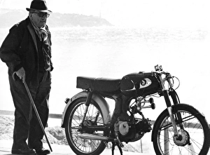 Old man standing next to a motorcycle near a beach Old man standing next to a motorcycle near a beach