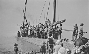 People on and around a boat by a jetty - France People on and around a boat by a jetty - France