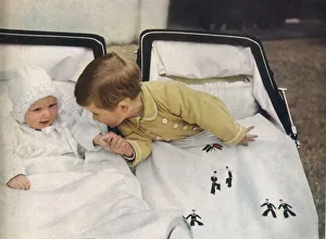 Prince Charles leans across his pram to take the hand of his baby sister, Princess Anne Prince Charles leans across his pram to take the hand of his baby sister, Princess Anne