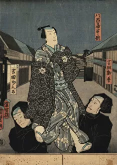 Puppet in kimono being manipulated by two bunraku puppeteers
