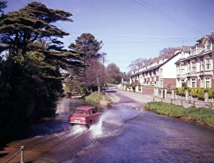 Red car driving through water, Sidmouth, Devon Red car driving through water, Sidmouth, Devon