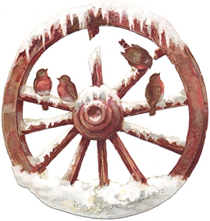 Robins perched on a wheel on a cutout Christmas card Robins perched on a wheel on a cutout Christmas card