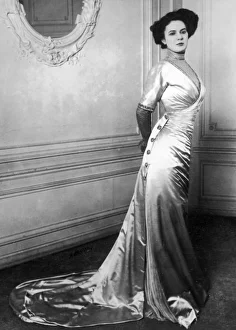 <b class=qtipBold><figcaption>Satin Evening Gown C1905</figcaption></b><br>Satin gown with wrap-over bodice buttons tightly over the hips before cascading in luxuriant folds to terminate in a train. The fashionable silhouette is achieved.<br><em>© Mary Evans Picture Library</em> Satin Evening Gown C1905