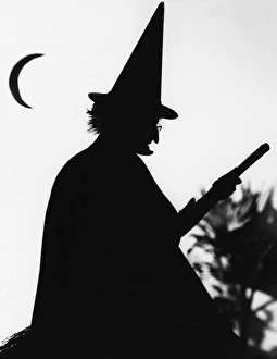 <b class=qtipBold><figcaption>Silhouette of a Witch</figcaption></b><br>A silhouette of a witch with her broom and a new moon. She has a particularly pointed nose and chin.<br><em>© Mary Evans Picture Library</em> Silhouette of a Witch