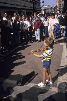 Small boy busking with his violin for an audience in Dublin Small boy busking with his violin for an audience in Dublin