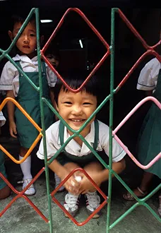 A small child behind the grill of a kindergarten, Hong Kong A small child behind the grill of a kindergarten, Hong Kong
