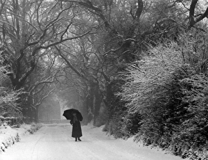 <b class=qtipBold><figcaption>Snow Scene/Pangbourne</figcaption></b><br>A woman with an umbrella stands on a snowy road. The trees look very pretty with snow on their branches. Date: February 1940<br><em>© Mary Evans Picture Library</em> Snow Scene/Pangbourne