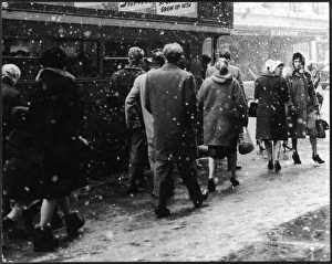 <b class=qtipBold><figcaption>Snowy London</figcaption></b><br>Passengers struggling to get on a Routemaster bus in heavy snow in central London.<br><em>© Mary Evans Picture Library/GERALD WILSON</em> Snowy London