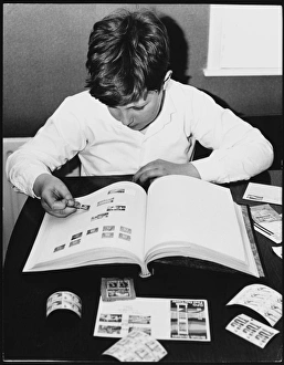 <b class=qtipBold><figcaption>Stamp Collecting 1960S</figcaption></b><br>A boy stamp collector, sticking stamps into his stamp book.<br><em>© Mary Evans Picture Library/TONY BOXALL</em> Stamp Collecting 1960S