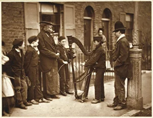 <b class=qtipBold><figcaption>Street Musicians 1877</figcaption></b><br>Boys and an old woman on her doorstep gather around Italian street musicians and their large harp.<br><em>© Mary Evans Picture Library</em> Street Musicians 1877
