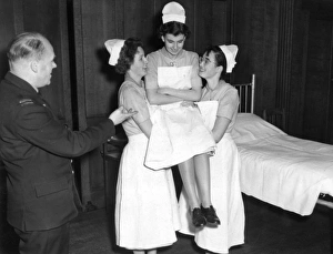 Student nurses practising three handed lift Student nurses practising three handed lift