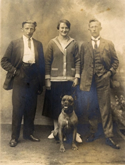 Studio portrait, three people with boxer dog Studio portrait, three people with boxer dog