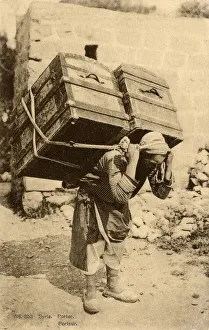 Syrian Porter carries two enormous trunks on his back Syrian Porter carries two enormous trunks on his back