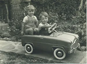 Childhood Gallery: A twin brother and sister, wearing matching dungarees, play together in a splendid toy