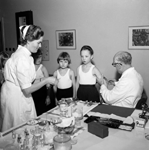 <b class=qtipBold><figcaption>Vaccinations</figcaption></b><br>A doctor and his nurse vaccinate schoolgirls againgst polio, Landskrona, Sweden 1957. Date: 1957<br><em>© Landskrona Museum / IBL / Mary Evans</em> Vaccinations