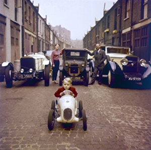 <b class=qtipBold><figcaption>Vintage Cars</figcaption></b><br>A little boy sits proudly in his model car, in front of three vintage cars parked on a cobbled street. Date: 1950s<br><em>© Mary Evans Picture Library</em> Vintage Cars