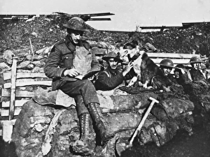 <b class=qtipBold><figcaption>Wartime Messenger Dog</figcaption></b><br>A soldier writes a message to give back to a French messenger dog on the Western Front in Belgium during World War I in 1917<br><em>© Mary Evans/Robert Hunt Collection</em> Wartime Messenger Dog