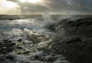 Waves splash against the shining black rocks at Knockbrex Waves splash against the shining black rocks at Knockbrex