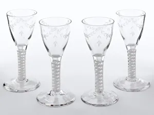 <b class=qtipBold><figcaption>Four wine glasses</figcaption></b><br>Wine glass with a double series opaque twist stem and tulip-shaped bowl engraved with swags of husk decoration, one of a set of four made in England c.1790. Date: c.1790<br><em>© The Geffrye Museum of the Home / Mary Evans Picture Library</em> Four wine glasses