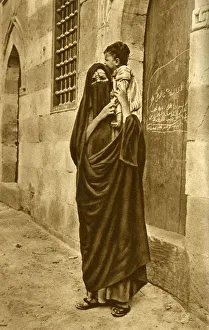 Woman in face veil with child on her shoulder, Cairo, Egypt Woman in face veil with child on her shoulder, Cairo, Egypt