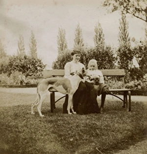 Woman and girl with dog and cat on a garden bench Woman and girl with dog and cat on a garden bench