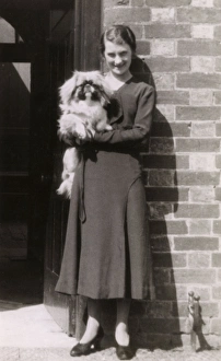 Woman with Pekingese dog outside a house Woman with Pekingese dog outside a house