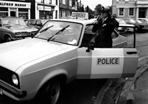 Woman police officer with car and radio, Egham, Surrey Woman police officer with car and radio, Egham, Surrey