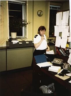 Epaulettes Gallery: Woman police officer on the phone in a police station