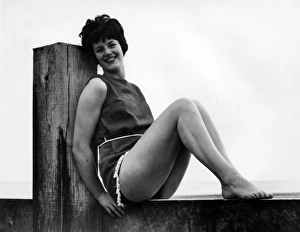 Woman at the seaside, leaning on a wooden post Woman at the seaside, leaning on a wooden post