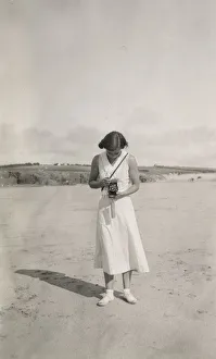 Woman taking a photograph on the beach Woman taking a photograph on the beach