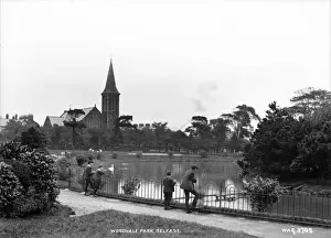 Prints of Woodvale Park, Belfast - a view of the park and pond with four boys in the foreground and a Church in the distance. (Location: Northern Ireland: County Antrim: Belfast). Date: circa early 1900s Belfast Prints: Woodvale Park, Belfast Print - Early 1900s