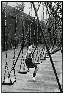 Young boy alone on a playground swing 1939 Young boy alone on a playground swing 1939