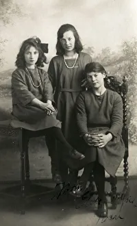 Three young ladies pose for a formal studio portrait Three young ladies pose for a formal studio portrait