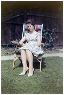 Suburbia Gallery: A young lady sat in a neat garden in a canvas-backed chair