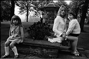 Young mother in a park with children bandstand and cyclist Young mother in a park with children bandstand and cyclist