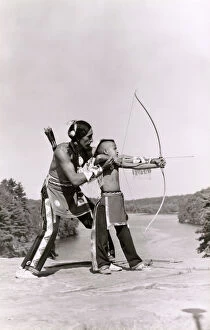 Teaching Gallery: Young Native American Indian boy learning to shoot his bow