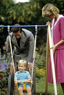A young Prince William on a swing next to his parents A young Prince William on a swing next to his parents