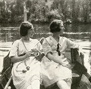 Two young women steering a barge on a river, England Two young women steering a barge on a river, England