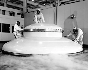 <b class=qtipBold><figcaption>Flying Saucer' Aliens'</figcaption></b><br>No, it's not a flying saucer, it is the domed top to a 70 foot long vacuum tank at the Lewis Research Center's Electric Propulsion Laboratory, Cleveland, Ohio. The three technicians shown here in protective clothing had just emerged from within the tank where they had been cleaning in the toxic mercury atmosphere, left after ion engine testing in the tank. Lewis has since been renamed the John H. Glenn Research Center.<br><em>© NASA</em> Flying Saucer' Aliens'