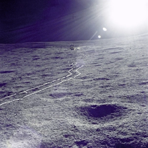 <b class=qtipBold><figcaption>Tracks to ''Antares''</figcaption></b><br>The Apollo 14 Lunar Module (LM) "Antares" is photographed against a brilliant sun glare during the first extravehicular activity (EVA-1). A bright trail left in the lunar soil by the two-wheeled Modularized Equipment Transporter (MET) leads from the LM.<br><em>© NASA</em> Tracks to ''Antares''