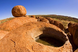 Devils Marbles - a nearly perfectly circular shaped boulder of red granite is balanced Devils Marbles - a nearly perfectly circular shaped boulder of red granite is balanced