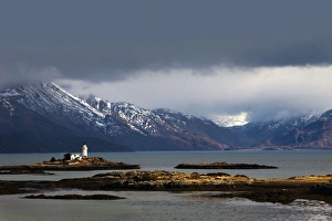 Lighthouse on the Isleornsay catching a moments sunshine in atmospheric conditions Lighthouse on the Isleornsay catching a moments sunshine in atmospheric conditions