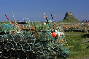 Lindisfarne, Holy Island - stacked lobster pots and view of castle Lindisfarne, Holy Island - stacked lobster pots and view of castle