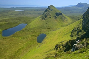 The Quiraing landscape - lakes and rolling velvet green slopes sprinkled with basaltic The Quiraing landscape - lakes and rolling velvet green slopes sprinkled with basaltic