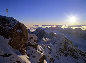 Sunrise on Zugspitze - view from highest mountain of Germany with summit cross at sunrise Sunrise on Zugspitze - view from highest mountain of Germany with summit cross at sunrise