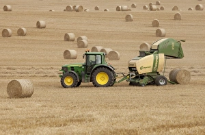 Tractor stopping to allow hay bale making machine to release bale of hay - September Tractor stopping to allow hay bale making machine to release bale of hay - September
