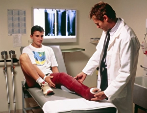 Doctor examining full leg cast of patient Doctor examining full leg cast of patient
