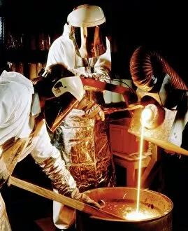 Foundry workers pouring molten metal into an ingot