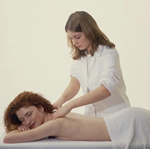 Masseuse massages the neck & shoulders of a woman Masseuse massages the neck & shoulders of a woman