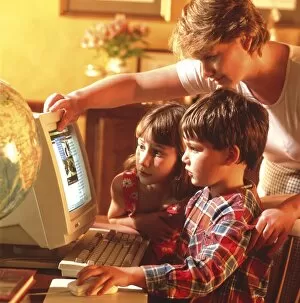 Images Dated 28th July 1999: Mother helping her children to use a home computer